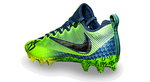 Back of Sherman's green and blue cleat with Nike swoosh and Seahawks feather pattern in blue